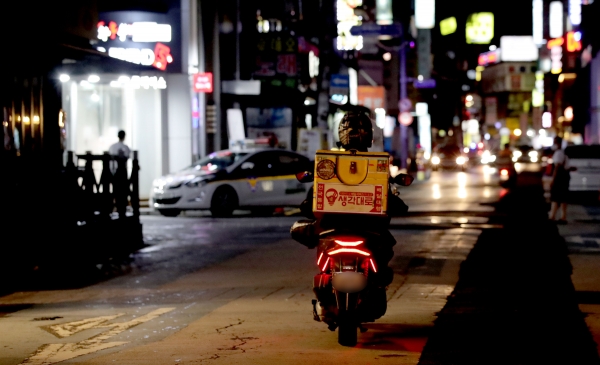 서울 송파구의 음식점 골목에서 한 배달기사가 오토바이를 타고 빠르게 지나고 있다. (이미지 제공: 뉴시스)