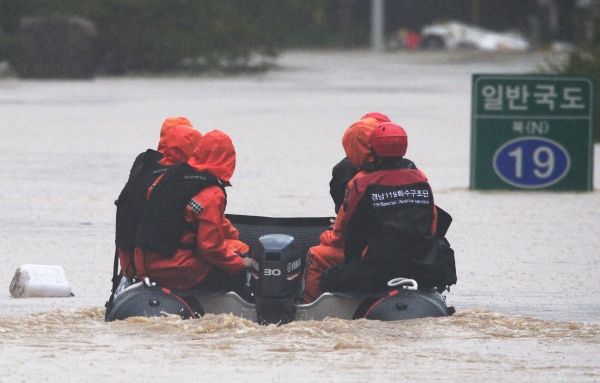 지난해 8월 8일 오후 이틀째 퍼부은 집중 호우로 섬진강이 범람하자 119 구조대가 경남 하동군 신지마을 인근에서 고립된 주민을 구조하기 위해 물에 잠겨버린 국도 19호선 위를 고무보트로 이동하고 있는 모습. (이미지 제공: 뉴시스)