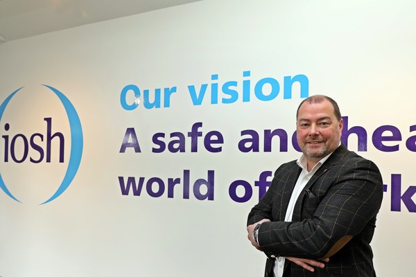 로렌스 웹(Lawrence Webb) IOSH 회장이 영국 레스터에 소재한 IOSH 본사 정문에 새겨진 슬로건 앞에서 기념촬영을 하고 있는 모습.